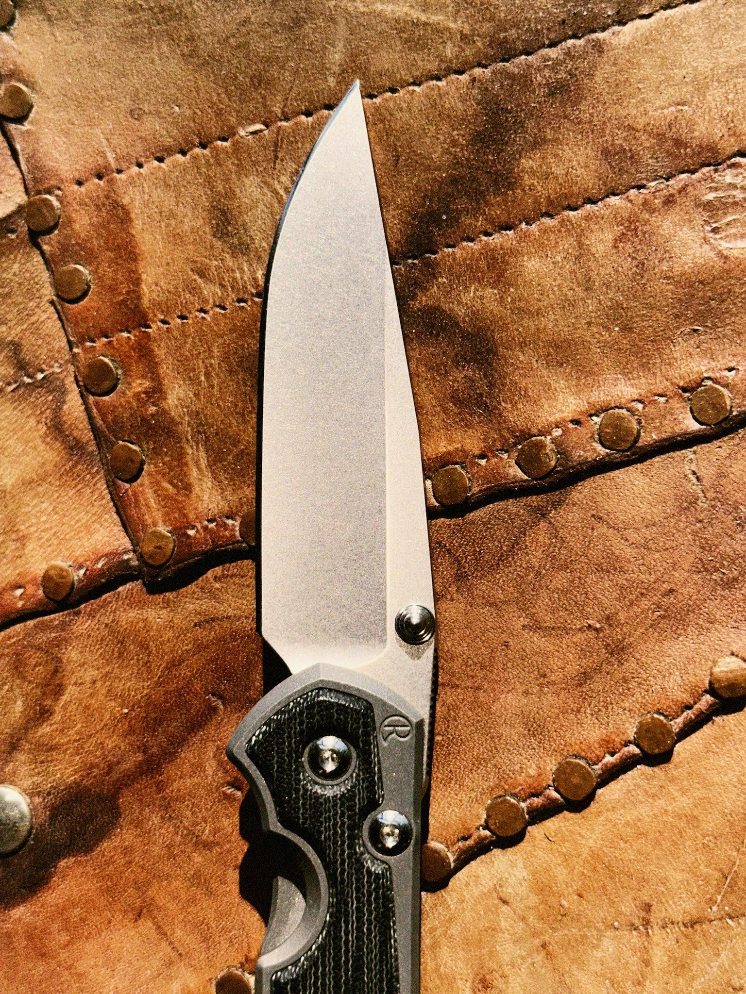 Chris Reeve Sebenza 31 S31-1200 CPM MagnaCut stonewash drop point blade close-up, hollow grind, thumb stud, notched thumb rest