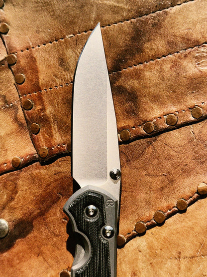 Chris Reeve Sebenza 31 S31-1200 CPM MagnaCut stonewash drop point blade close-up, hollow grind, thumb stud, notched thumb rest